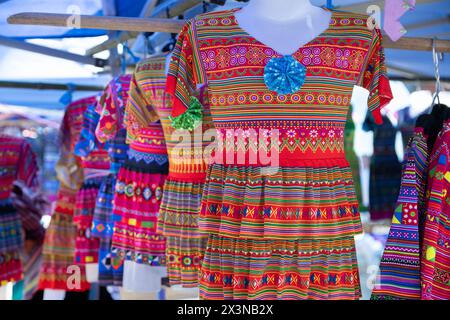 Colorato abbigliamento Hmong floreale in vendita al mercato CAN Cau nella provincia di Lao Cai, Vietnam Foto Stock