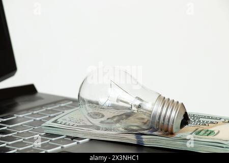 La lampada a incandescenza si basa sui dollari del computer portatile, sul prezzo elevato dell'elettricità, acquista luce online Foto Stock
