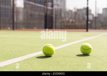 Pallina da tennis gialla e verdognola luminosa su un campo dipinto di recente Foto Stock