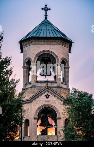 Campanile vicino alla cattedrale di Sameba al tramonto a Tbilisi, Georgia Foto Stock