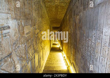 Corridoio stretto con rilievi che scendono dal tetto del Tempio di Hathor al complesso del Tempio di Dendera a Qena, in Egitto Foto Stock