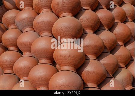 Vaschette di fango in terra per l'immagazzinamento dell'acqua appena realizzate e impilate una sopra per l'asciugatura alla luce del sole. Queste pentole raffreddano naturalmente l'acqua potabile. Foto Stock