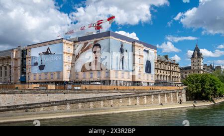 Grandi cartelloni pubblicitari di Yves Saint Laurent che coprono le impalcature dei lavori di restauro di un edificio lungo la Senna, Parigi, Francia Foto Stock