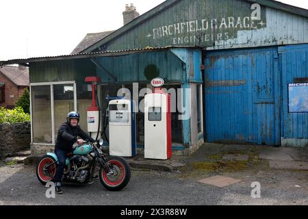 Motociclista su una motocicletta costruita su misura in un vecchio garage in disuso a molto Wenlock, nello Shropshire Foto Stock