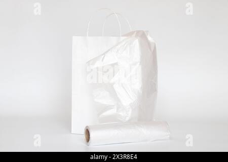 Sacchetto di carta bianca e sacchetto di plastica trasparente su sfondo bianco, confezione Foto Stock