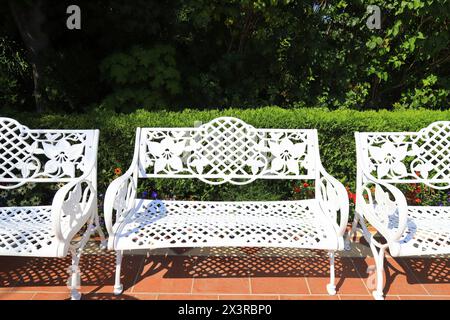 Mobili da giardino estivi. Panchine bianche in stile retrò nel caffè sulla terrazza. Mobili da esterno, bella panca aperta in giardino. Foto Stock
