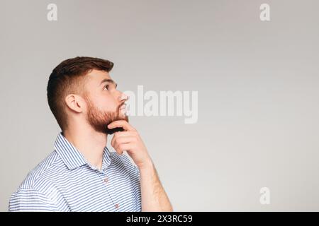 Ritratto di pensosa guy su sfondo beige Foto Stock