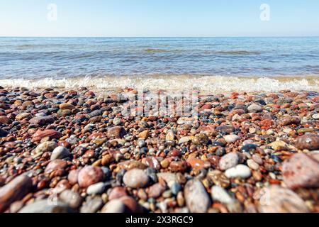 Onde in mare vicino alla costa su una spiaggia di ciottoli vuota. Mare e spiaggia. Vista panoramica sulla costa dell'oceano. Foto Stock