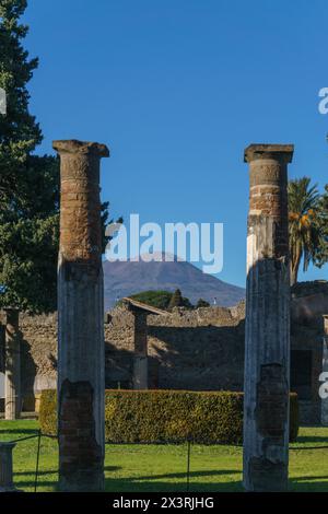 Giardino all'interno dell'antica casa di lusso Casa del Fauno tra le rovine di Pompei con vista attraverso le colonne del vulcano Vesuvio, Pompei, Campania, Italia Foto Stock