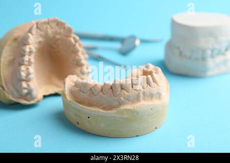 Modelli dentali con gengive e strumenti dentali su sfondo azzurro. Fusione di denti Foto Stock