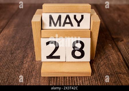 Primo piano di un calendario perpetuo in legno che mostra il 28 maggio. Foto Stock