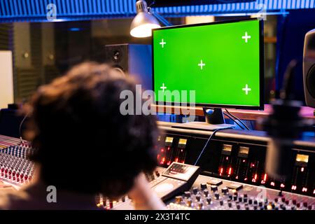 Artisti che registrano e modificano musica per produrre un nuovo album in studio professionale in sala di controllo, lavorando insieme per mixare e padroneggiare la musica. Team di musicisti che creano nuove tracce. Foto Stock