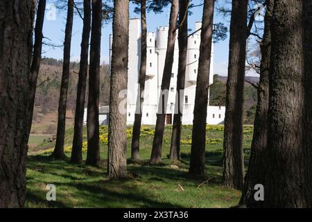 Guardando verso il castello di Braemar a Royal Deeside dal bosco di pini scozzesi (Pinus Sylvestris) nel terreno Foto Stock