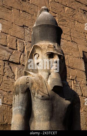 Statua di Ramses II, primo pilone di Ramses II, Tempio di Luxor, sito patrimonio dell'umanità dell'UNESCO, Luxor, Egitto Foto Stock