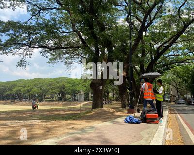 Quezon City, Filippine. 29 aprile 2024. I lavoratori si proteggono dal calore estremo con un ombrello. Crediti: Girlie Linao/dpa/Alamy Live News Foto Stock