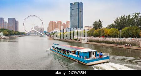 Panorama di una barca turistica che naviga verso la ruota panoramica Tianjin Eye a Tianjin, Cina Foto Stock