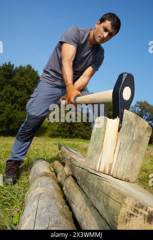 Agricoltore che taglia legno con cuneo, cuneo martello, utensile manuale agricolo e da giardinaggio, Usurbil, Gipuzkoa, Paesi Baschi, Spagna Foto Stock