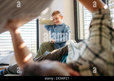 Lotta tra il figlio e il padre. Papà passa del tempo con il figlio a casa, divertendosi. Foto Stock