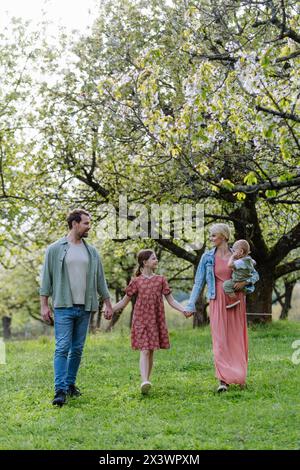 Ritratto di famiglia con la figlia e il bambino piccolo, il bambino, camminando all'aperto nella natura primaverile. Foto Stock