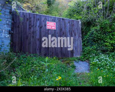 Aprile 2024 - cartello segnaletico di proprietà privata su una grande porta di casa nel bosco sopra il villaggio di Cheddar nel Somerset. Foto Stock