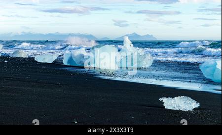 Una spiaggia con un grande specchio d'acqua e molto ghiaccio Foto Stock