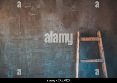 Scala in legno appoggiata alla parete di cemento del cantiere come spazio di copia Foto Stock