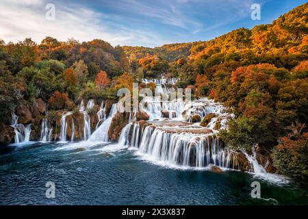 Krka, Croazia - Vista aerea delle splendide cascate di Krka nel Parco Nazionale di Krka in una soleggiata mattinata d'autunno con colorate foglie autunnali e cielo blu Foto Stock