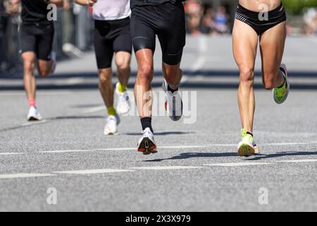 Gambe di corridori maschili e femminili durante la maratona Foto Stock