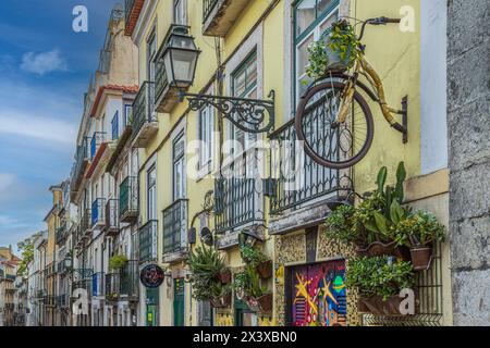 LISBONA, PORTOGALLO - 7 APRILE 2024: Divertenti decorazioni di strada, con parti di biciclette, graffiti e dipinti di strada sulle facciate delle case di Rua da Rosa Foto Stock