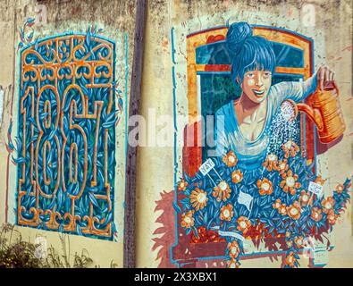 LISBONA, PORTOGALLO - 6 APRILE 2024: Belle decorazioni di strada con dipinti di strada sulle facciate delle case nel pittoresco quartiere di Alfama, antico quartiere storico Foto Stock