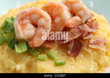 Gamberi freschi e gustosi, pancetta, fiocchi d'avena e cipolla verde sul piatto, primo piano Foto Stock