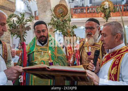 Bartella, Iraq. 28 aprile 2024. I sacerdoti conducono la domenica delle Palme, segnando l'inizio della settimana Santa per i cristiani ortodossi, presso la Chiesa siriaca ortodossa di Mart Shmoni. (Foto di Ismael Adnan/SOPA Images/Sipa USA) credito: SIPA USA/Alamy Live News Foto Stock