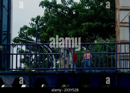 Una madre che ha portato i suoi due figli a camminare sul ponte pedonale Foto Stock