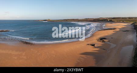 Vista panoramica aerea del percorso della costa inglese lungo la spiaggia di Embleton Bay e il castello di Dunstanburgh al tramonto Foto Stock