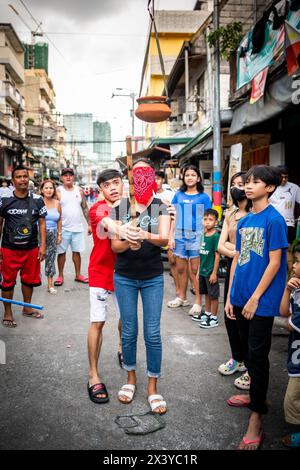 I bambini filippini giocano giochi di strada insieme durante una celebrazione religiosa annuale e un festival nel distretto di tondo. Foto Stock