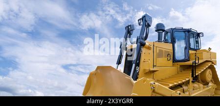 Bulldozer giallo pesante su uno sfondo di cielo blu Foto Stock