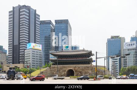 Vista generale della porta di Namdaemun, uno dei simboli di Seoul, dal centro di Seoul. Namdaemun (South Great Door), ufficialmente conosciuta come Sungnyemun (Honor propriety Gate), è una delle otto porte della Fortezza Muraglia di Seul, Corea del Sud. Namdaemun, risalente al XIV secolo, è una storica porta in stile pagoda ed è designata come il primo Tesoro Nazionale della Corea del Sud. Namdaemun fu costruita per la prima volta durante il regno di Joseon nel 1398 e ricostruita nel 1447. Nel 2008, la pagoda di legno in cima alla porta fu gravemente danneggiata da incendi dolosi. I lavori di restauro della porta sono iniziati nel febbraio 2010 ed è stato co Foto Stock