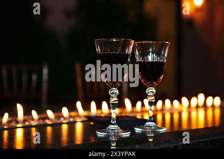 Due bicchieri da vino con romantico lume di candela. Foto Stock