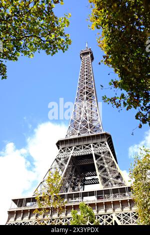 Torre Eiffel contro un cielo blu limpido, incorniciata da foglie d'autunno. Foto Stock