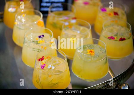 Cocktail colorati decorati con delicati fiori commestibili. Foto Stock