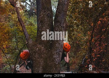 Due amici che indossano teste di zucca di Halloween intagliate Foto Stock