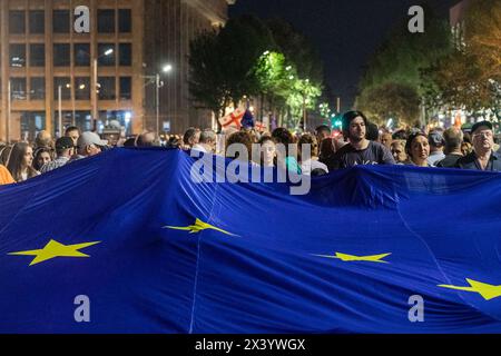 Tbilisi, Georgia. 28 aprile 2024. I manifestanti marciano con la bandiera dell'Unione europea durante una protesta contro la reintroduzione di un disegno di legge sugli "agenti stranieri” nel centro di Tbilisi. Credito: SOPA Images Limited/Alamy Live News Foto Stock