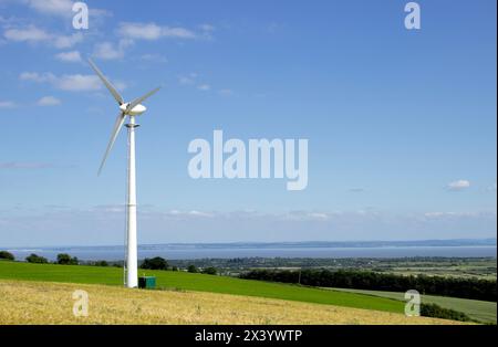 Turbina eolica sul versante collinare dell'orzo, cielo azzurro Bassaleg, Newport, Galles, Regno Unito Foto Stock