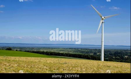 Turbina eolica sul versante collinare dell'orzo, cielo azzurro Bassaleg, Newport, Galles, Regno Unito Foto Stock