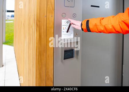 Pagamento senza contatto servizi igienici pubblici con carta di credito, visita al bagno pubblico nella sala Tesla-Supercharger, routine di igiene quotidiana, Berlino, Germania - A. Foto Stock