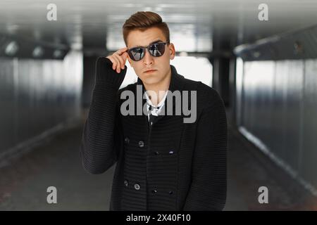 Young Man regola i suoi occhiali da sole Foto Stock