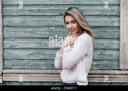 Bella ragazza sullo sfondo di un vecchio muro di legno con Un rigato Foto Stock