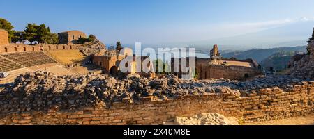 Rovine di un teatro greco e vista sulla costa di Taormina, Sicilia, Italia; Taormina, Sicilia, Italia Foto Stock