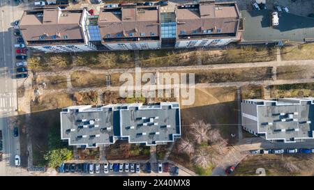 Fotografia di case a più piani, strade e marciapiedi in una città durante il giorno di sole primaverile Foto Stock