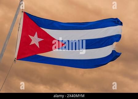 Bandiera cubana che sventola orgogliosamente contro un cielo coperto al crepuscolo; Cayo Guillermo, Cuba Foto Stock